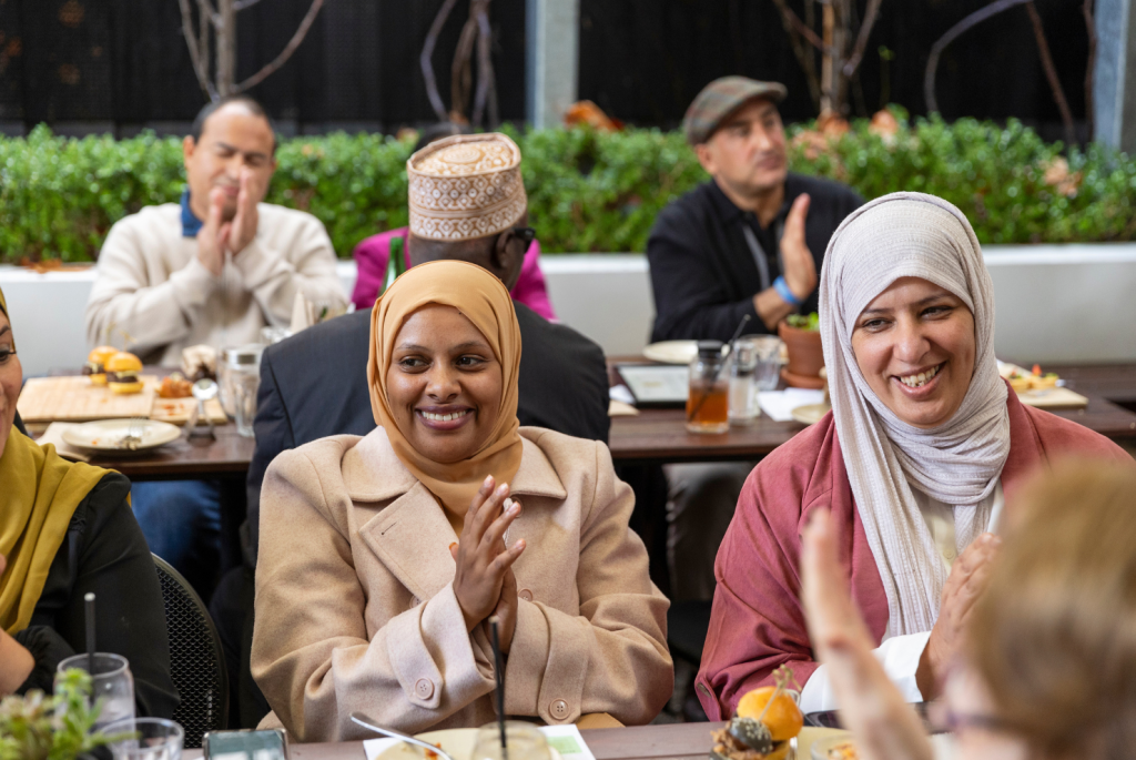 Two ladies smiling sitting at a table.